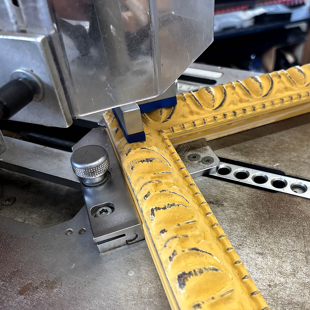 An ornate yellow frame on a pining machine.